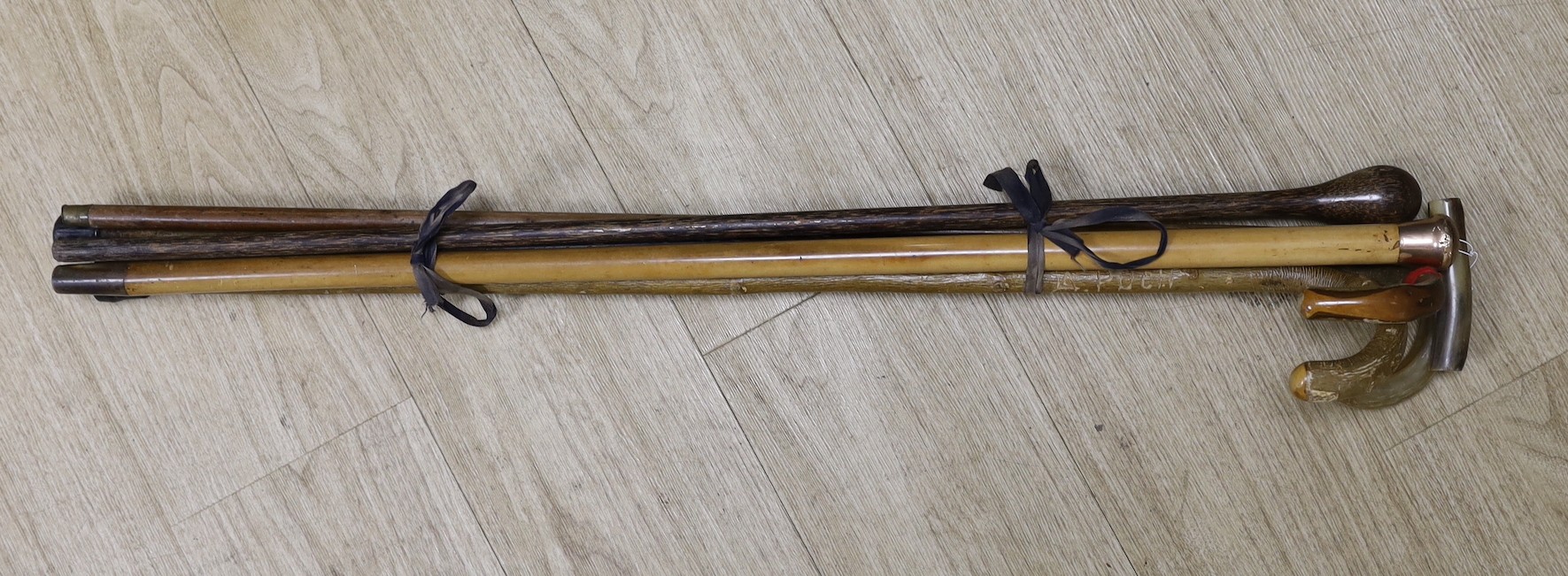 A gold mounted Mallacca walking cane, two horn handled walking sticks and three others.
